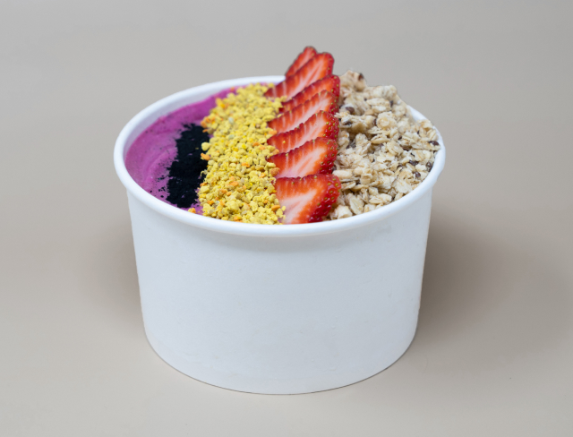 Our Strawberry Acai Bowl in a white paper bowl