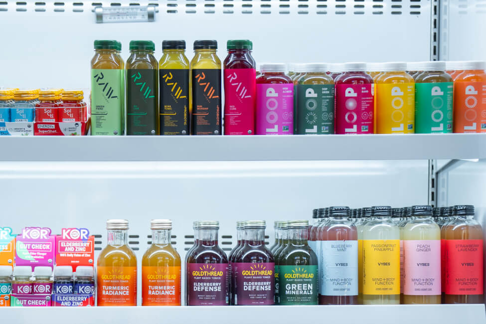 Selection of cold pressed juices and juice shots in a cooler