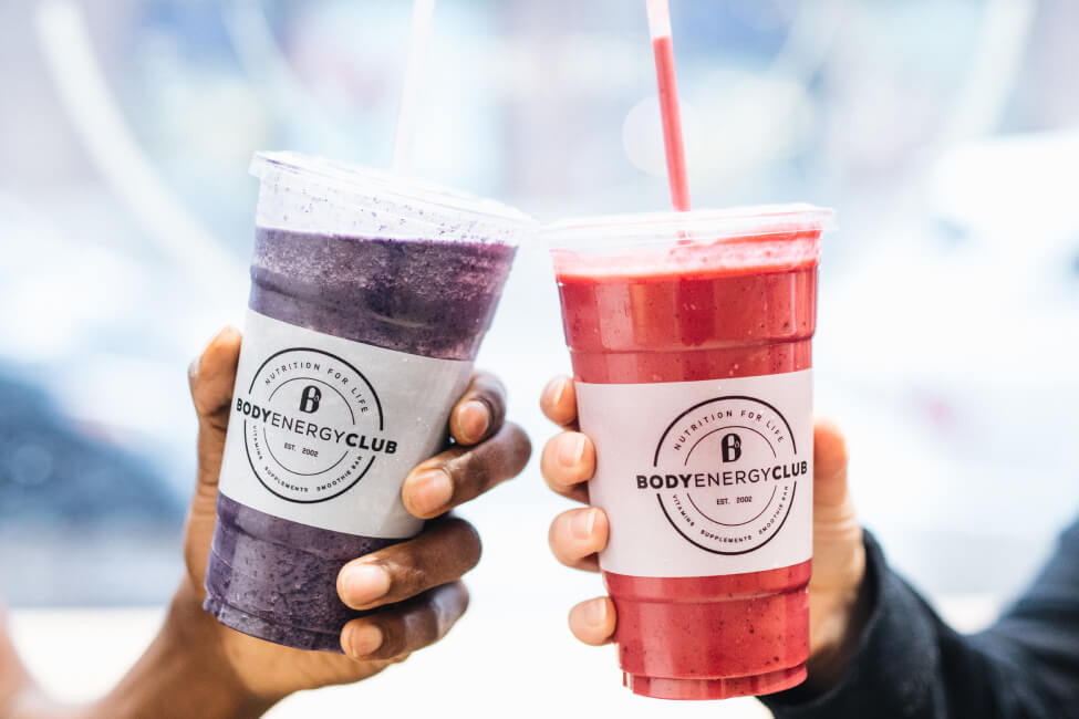 Two people tapping together their smoothies